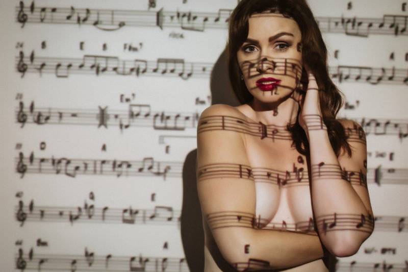 Sheet music projected onto nude